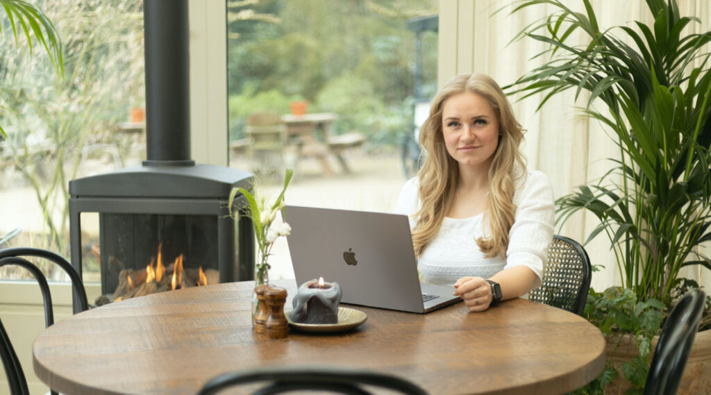 Anouk at the table behind the laptop