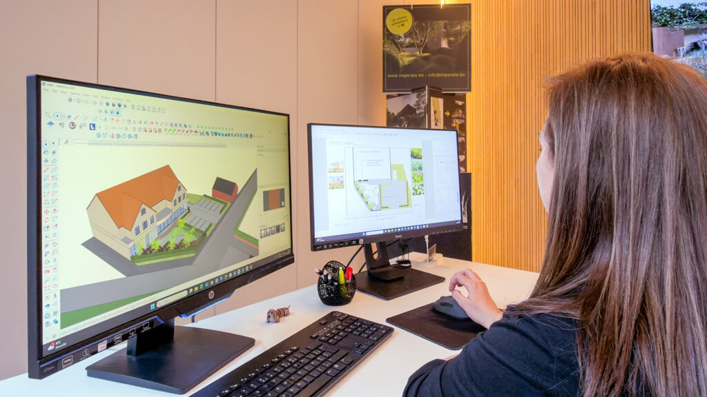 Een over-de-schouder perspectief van het ontwerpproces. Op het scherm is een gedetailleerd SketchUp-model zichtbaar van een vrijstaand huis met oprit en voortuin, klaar voor verdere uitwerking.
