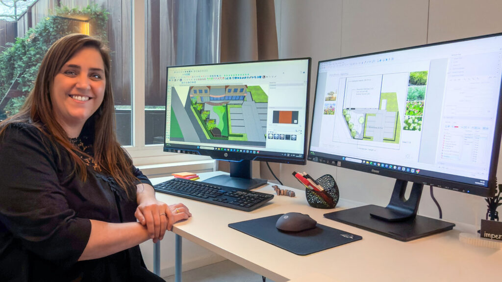 Tuinontwerpster Marlies aan het werk achter twee beeldschermen in de studio van Imperata. Het linkerscherm toont het 3D-tuinmodel van een woonhuis in SketchUp, en het rechterscherm het uitgewerkte 2D-beplantingsplan in LayOut
