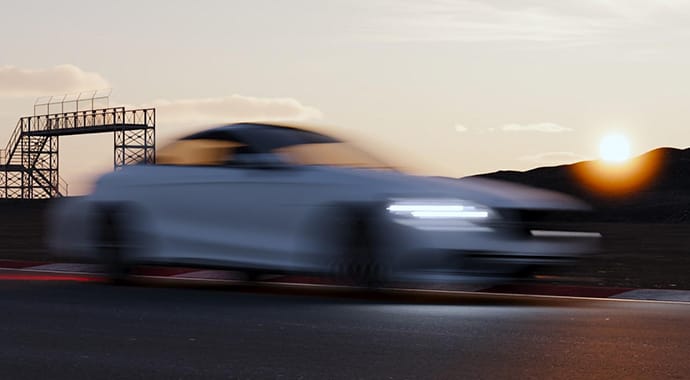 Een dynamische 3D-render van een voorbijscheurende witte auto op een racecircuit bij zonsondergang. De extreme motion blur (bewegingsonscherpte) op de auto demonstreert de fotorealistische camera-instellingen van Chaos Corona, waarbij een echte sluitertijd fysiek accuraat wordt gesimuleerd.