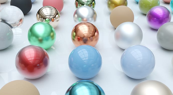 Een verzameling van diverse 3D-bollen op een glanzend wit oppervlak, elk met een ander materiaal zoals chroom, mat plastic en gekleurd glas. Dit illustreert de Chaos Corona Material Converter voor het eenvoudig omzetten en standaardiseren van materialen.