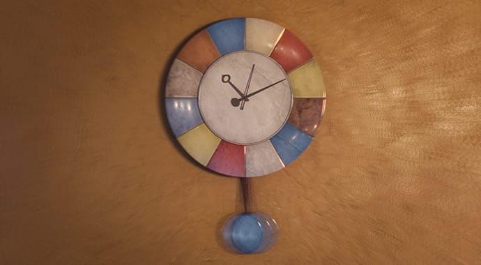 Een fotorealistische 3D-render van een hangende slingerklok met een wijzerplaat gemaakt van kleurrijke vlakken, gebruikt om de tijdbesparende 'Resumable Rendering' feature van Chaos Corona te visualiseren.