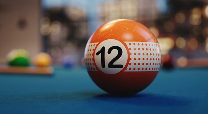 Een macro 3D-render van een realistische oranje biljartbal met het nummer 12 op een groene tafel, met een sterke scherptediepte. De bal toont gedetailleerde krassen en een grafische opdruk die eenvoudig en naadloos is toegepast via de Chaos Corona Decal functie.
