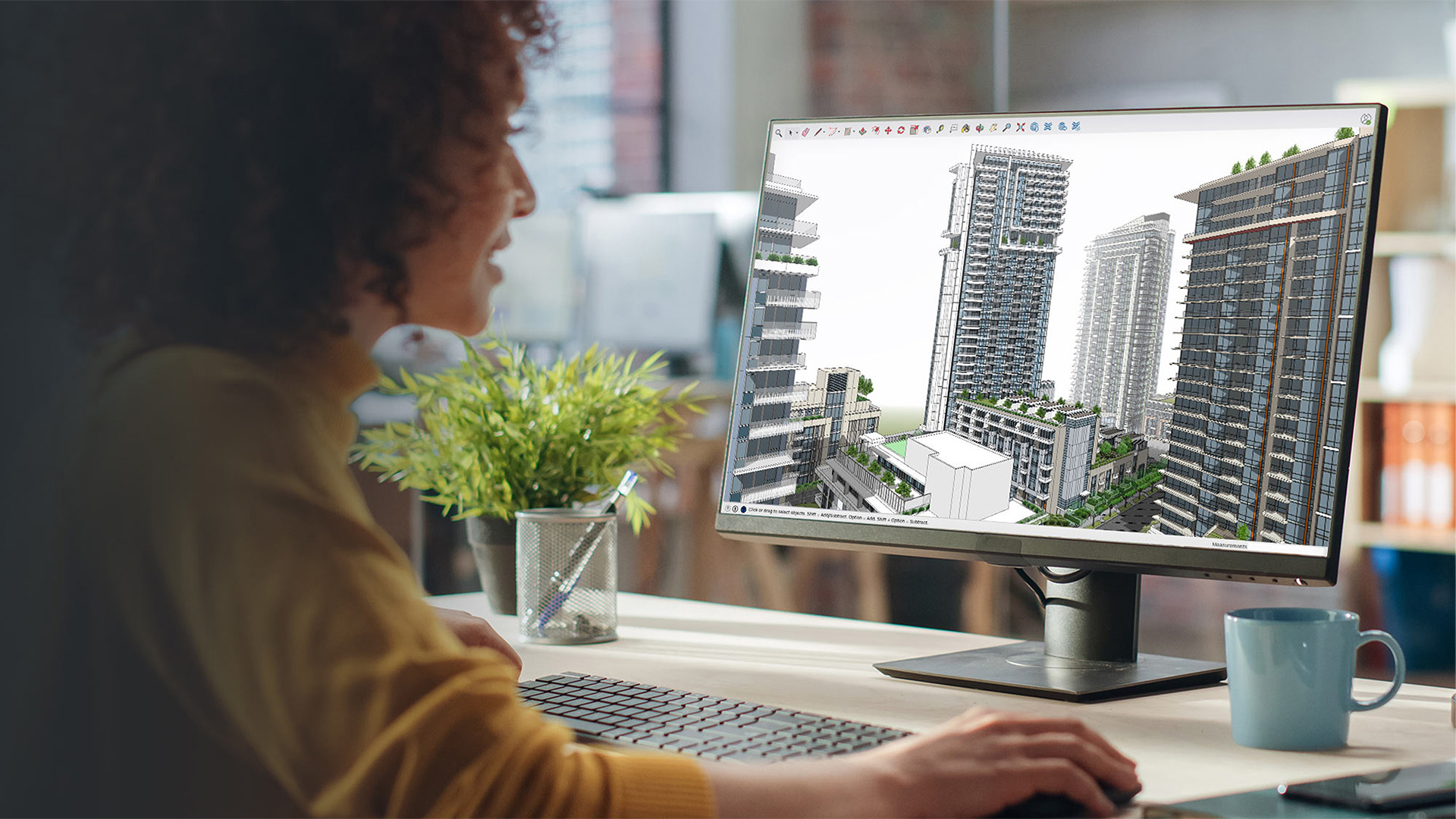 Een professionele ontwerpster kijkt naar haar beeldscherm, waarop ze werkt aan een complex 3D-stadsmodel met gedetailleerde wolkenkrabbers in SketchUp. Dit illustreert het hoge detailniveau en de complexe workflows die centraal staan in de SketchUp Vervolgtraining.